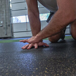 forearm stretch on gym floor for wrist mobility