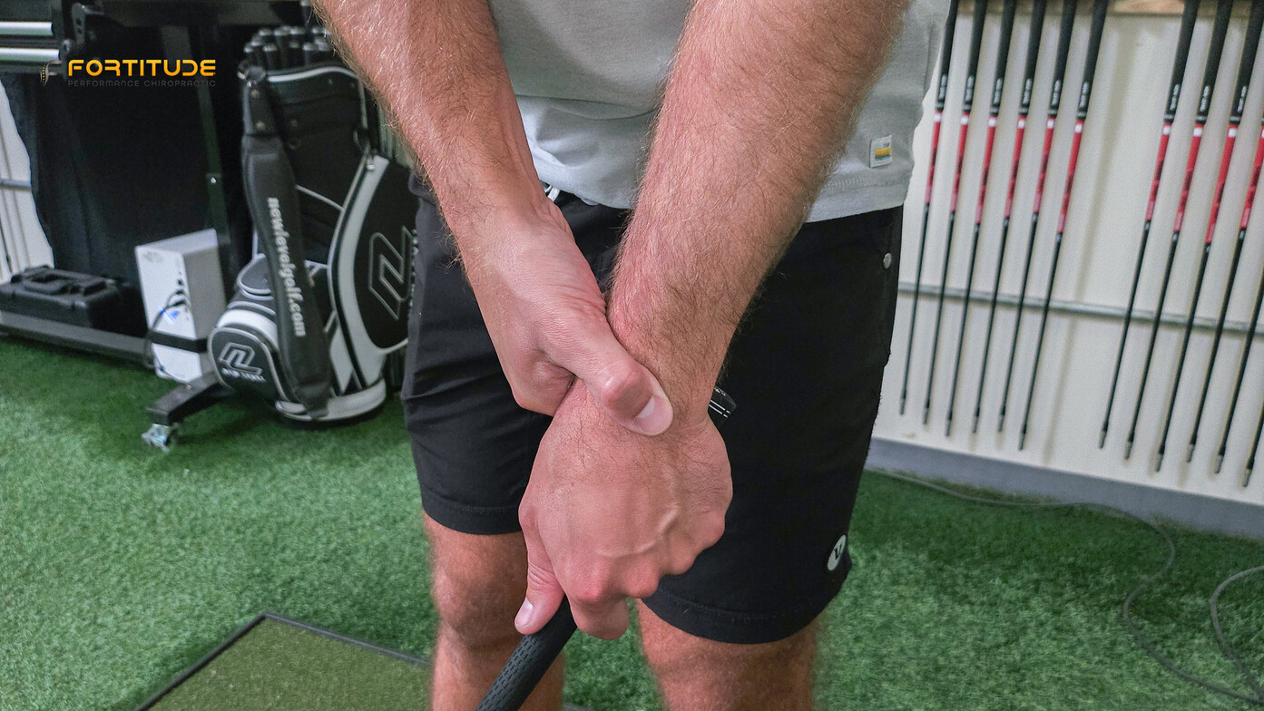 golfer with wrist pain holding wrist in pain
