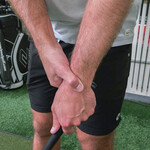 golfer with wrist pain holding wrist in pain
