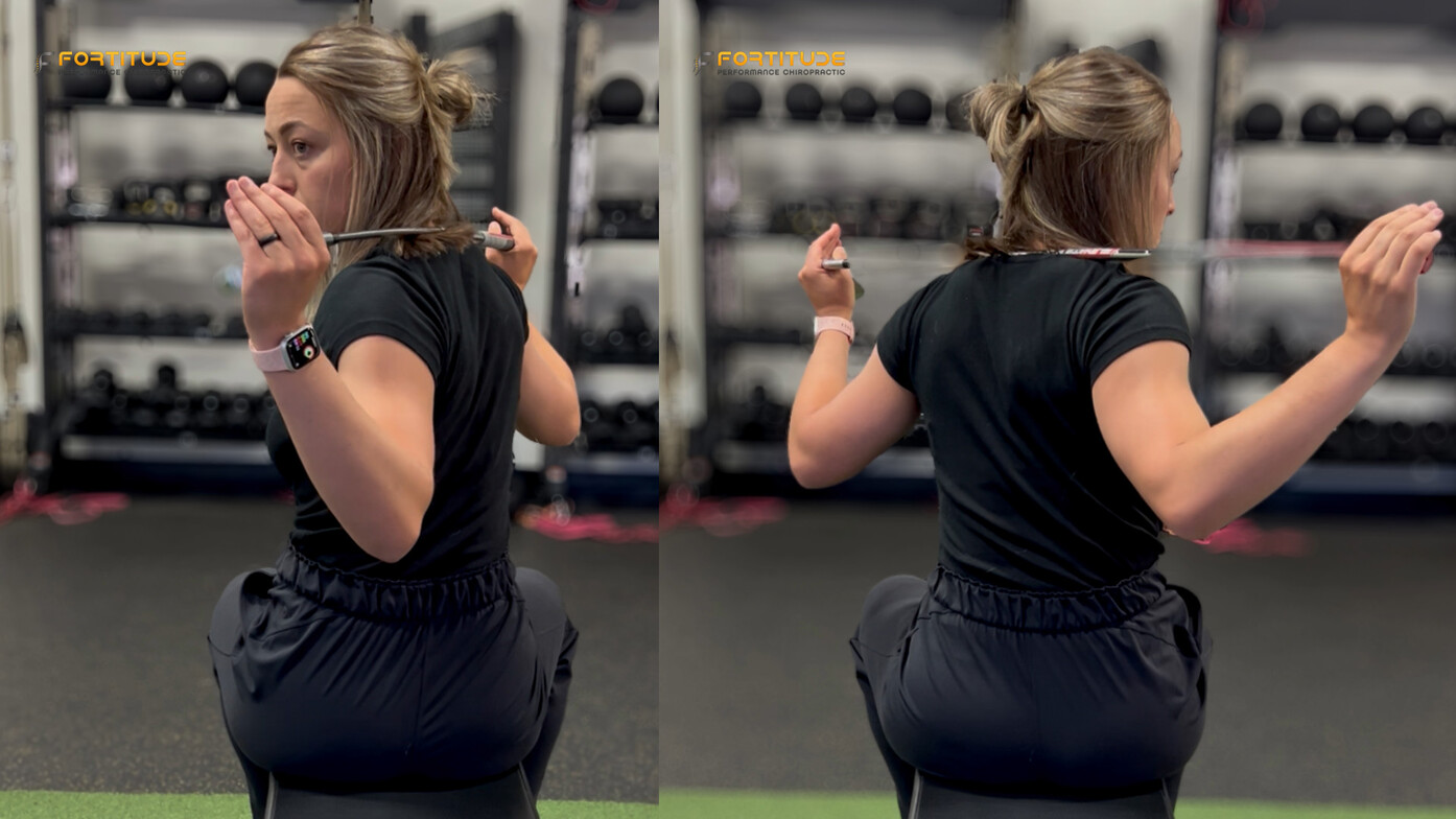 Seated woman performing golf rotation drill with a club across her shoulders to assess trunk mobility